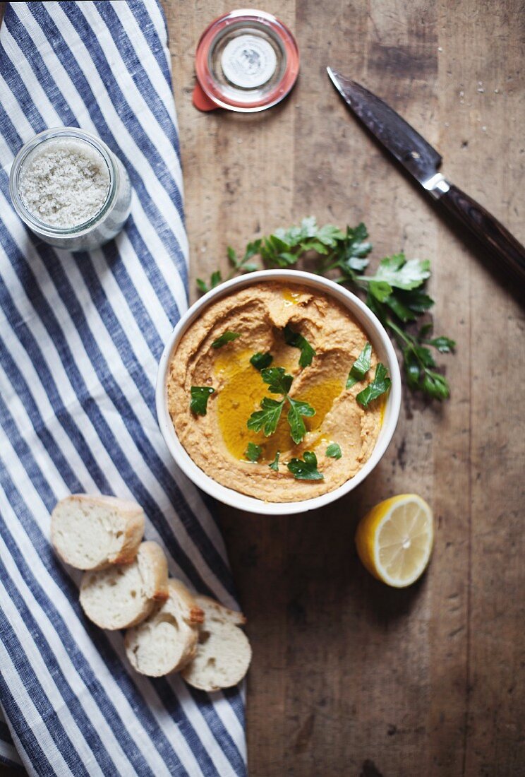 Hummus mit frischer Petersilie, Zitrone und Baguette (Draufsicht)