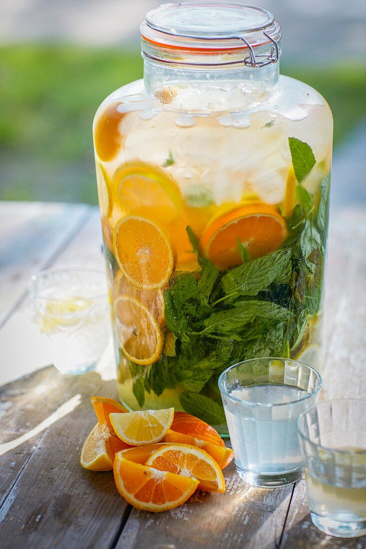 Homemade orangeade with orange slices and mint in a preserving jar