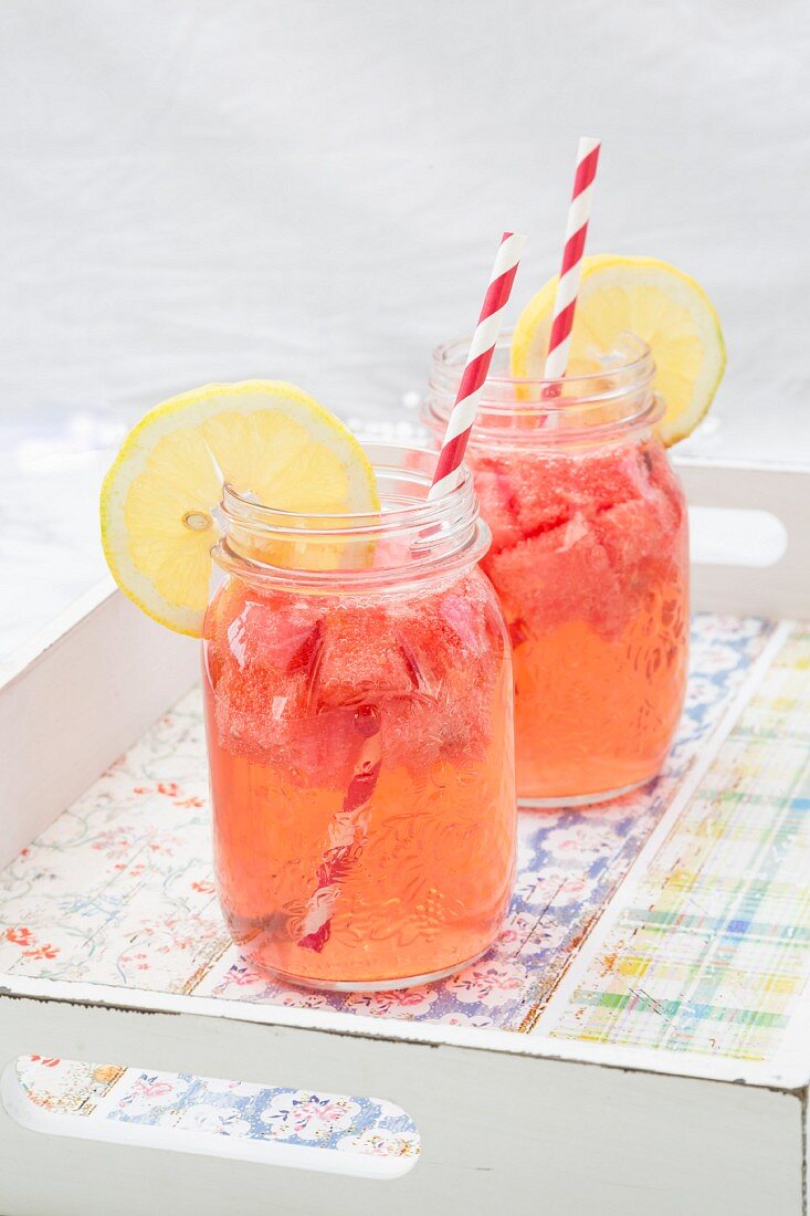 Two glasses of homemade watermelon lemonade on a tray