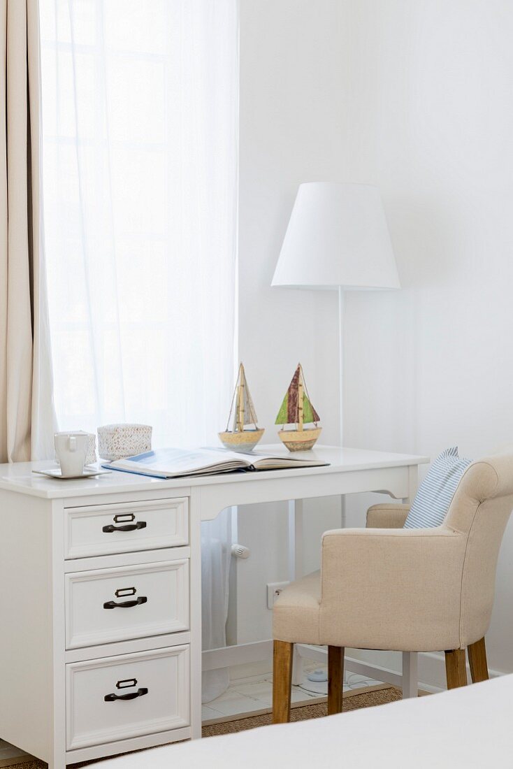 Elegant desk and upholstered chair below window