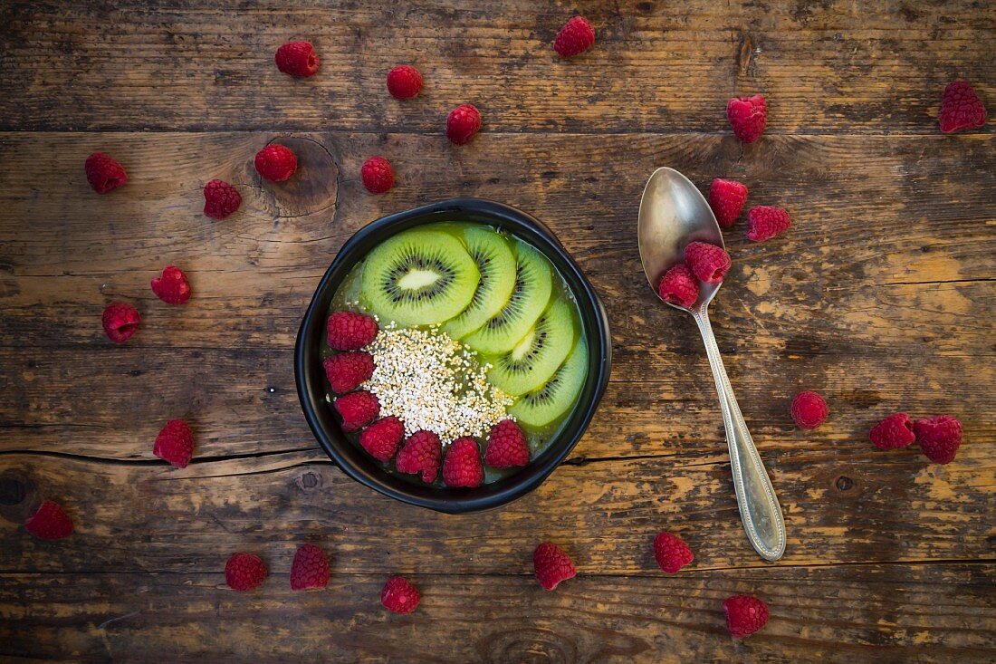 A smoothie bowl with amaranth, chia seeds, raspberries and kiwi (seen from above)