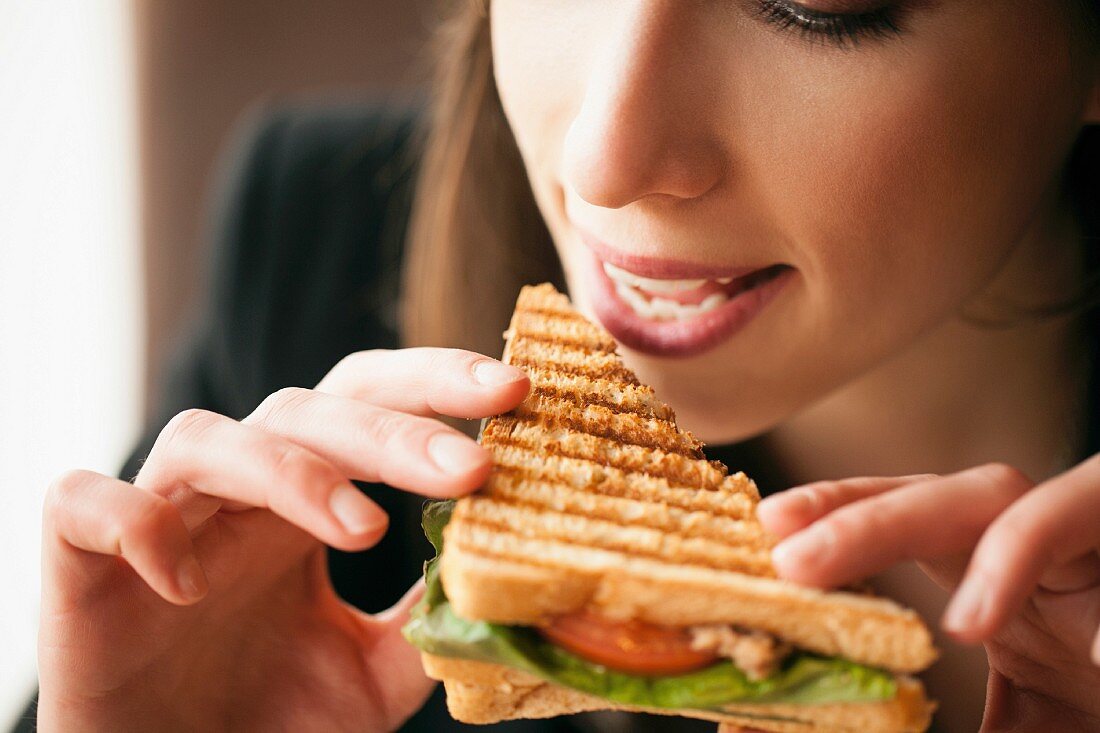 Frau isst Sandwich (Nahaufnahme)