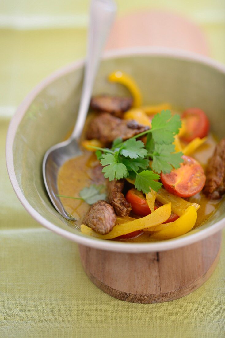 Yellow beef curry with peppers and tomatoes