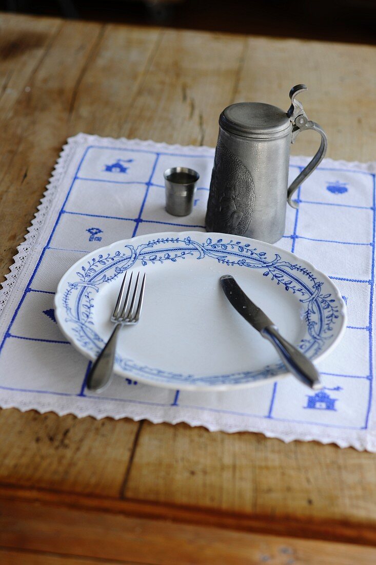 A rustic place setting with a pewter beer tankard