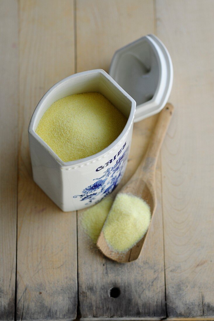 Semolina in a porcelain container and on a wooden spoon