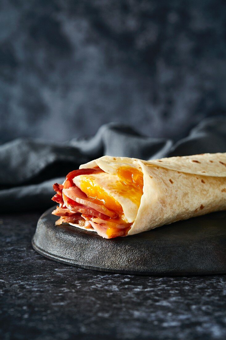 A breakfast wrap filled with bacon and egg
