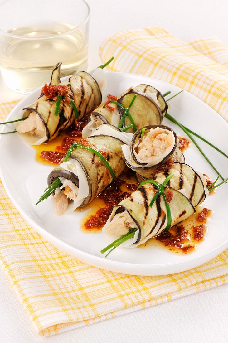 Aubergine rolls filled with fish in a tomato oil