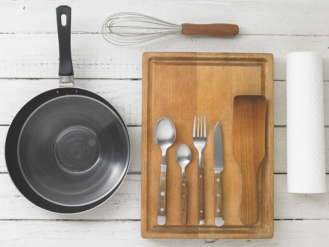 Kitchen utensils: a pan, a whisk, cutlery and a spatula
