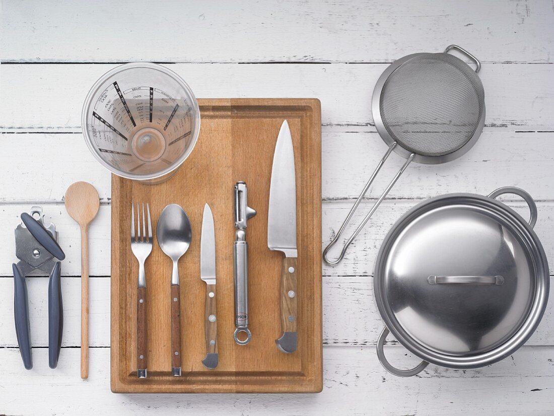 Kitchen utensils: a pot, a sieve, knives, cutlery, measuring jug and a tin opener