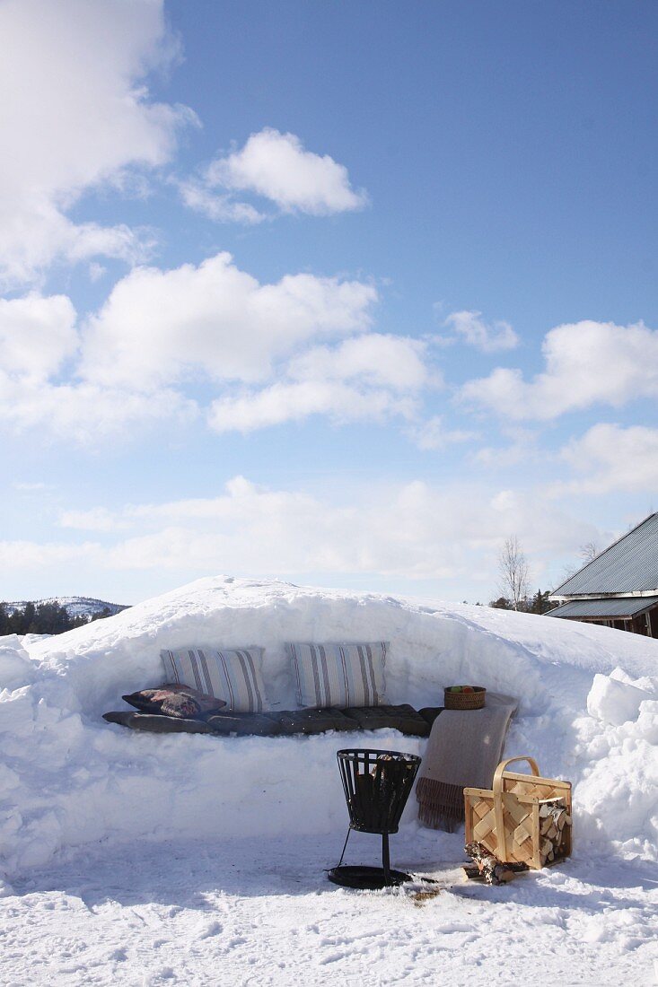 Winter picnic on bench carven from snow below blue sky