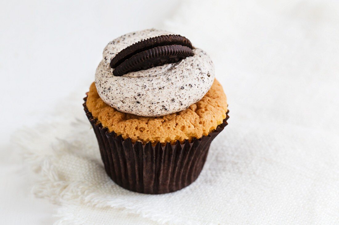 A cupcake decorated with coffee cream and an Oreo