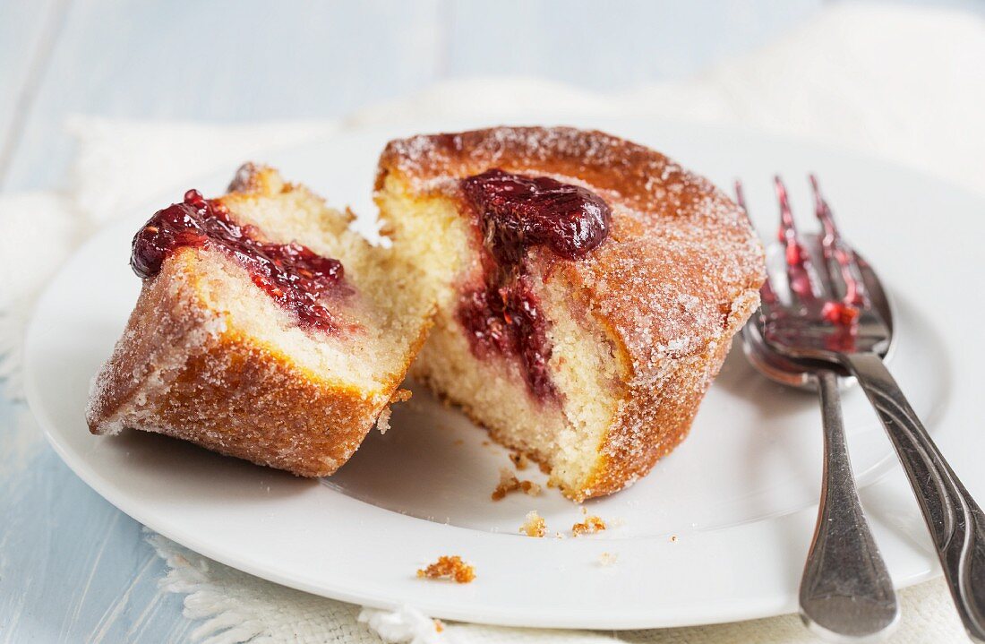 A doughnut muffin with raspberry jam, sliced