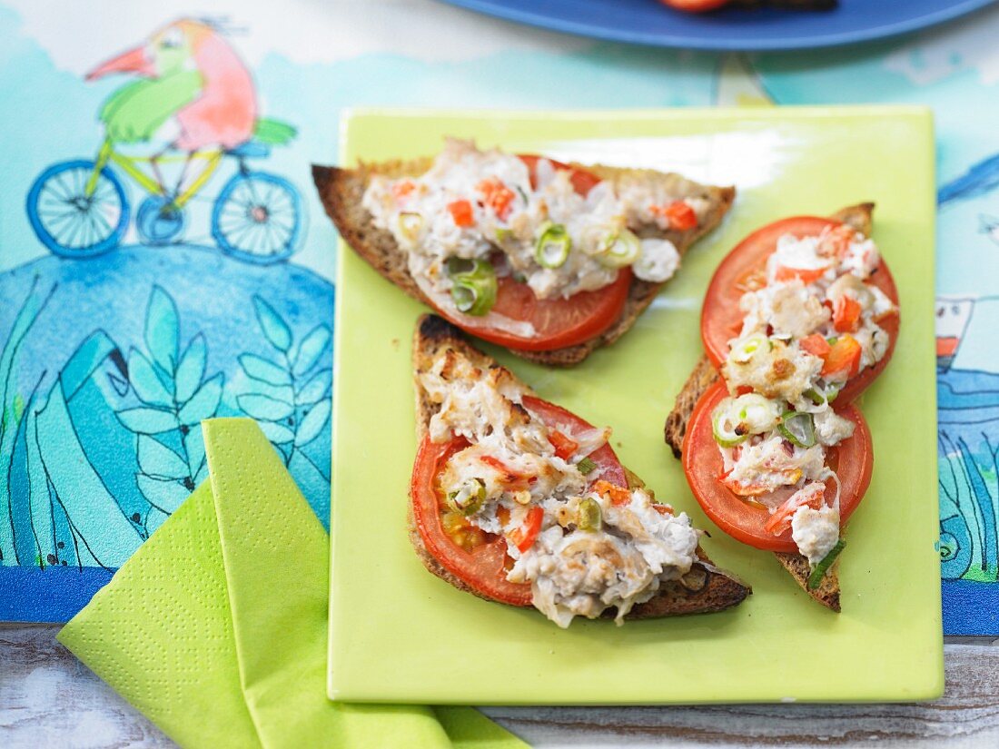 Gratinated toast triangles with sausage meat, peppers, tomatoes and spring onions