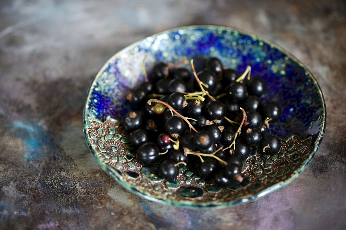Blackcurrants in a blue ceramic bowl