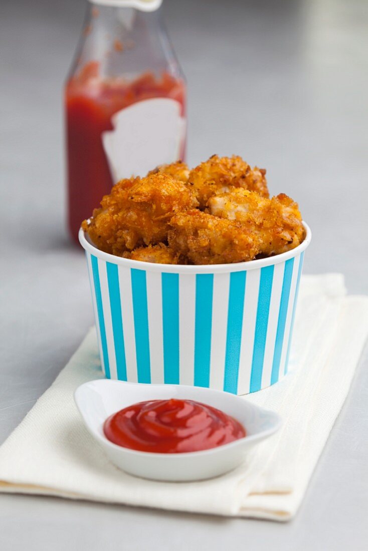 Chicken nuggets with a cornflakes crust served with ketchup