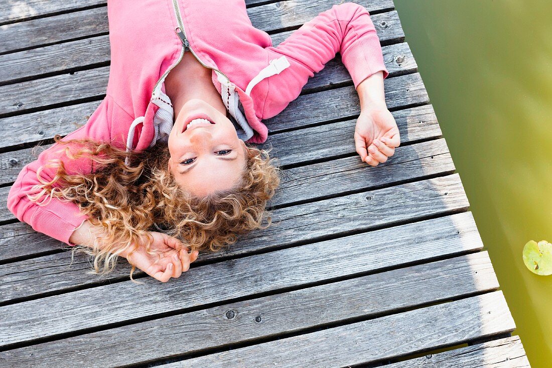 A young woman lying on a wooden jetty
