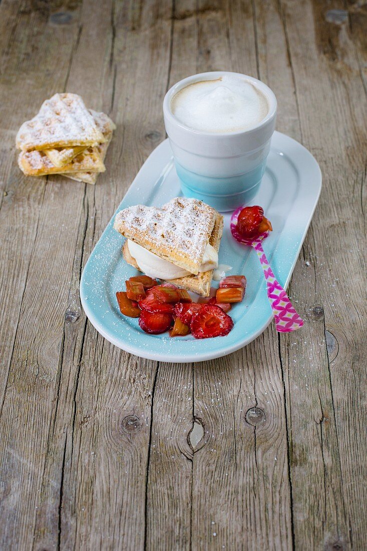 A waffle sandwich with frozen yoghurt, strawberry and rhubarb compote and cappuccino