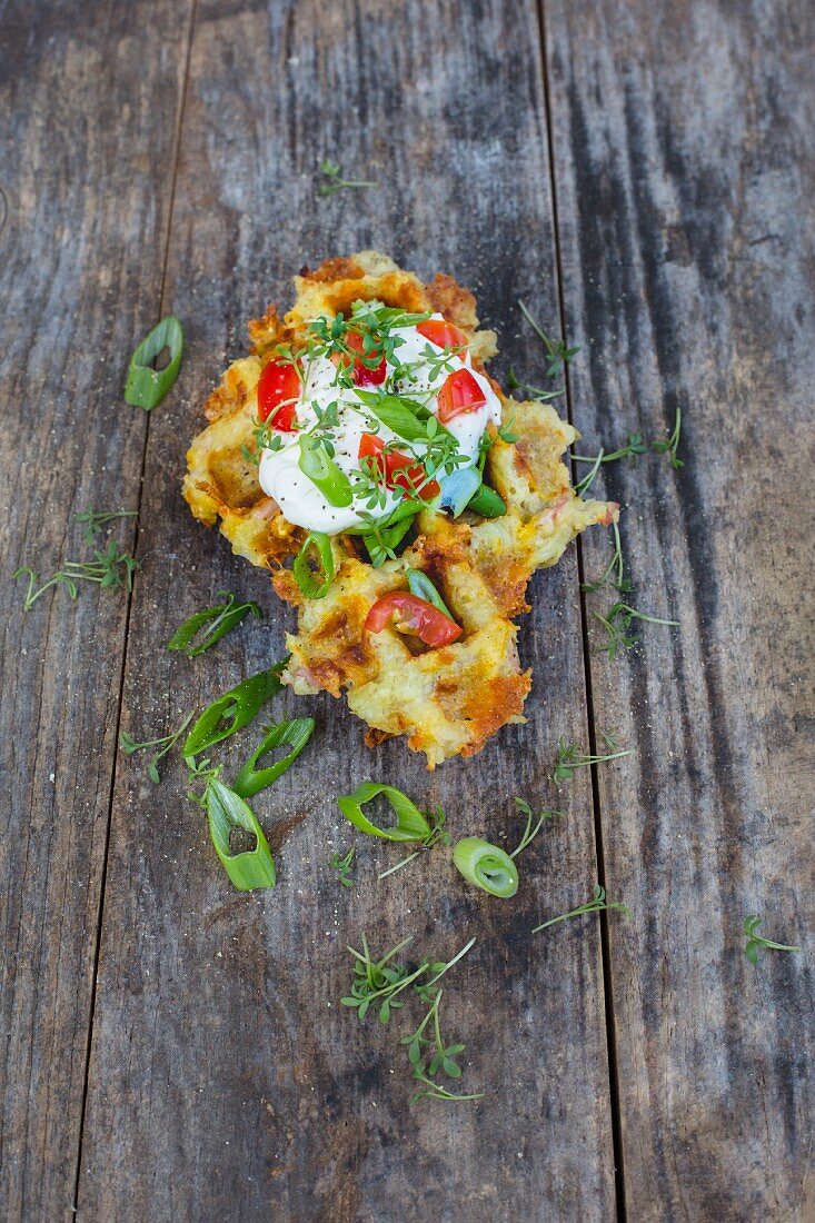 A potato fritter waffle with crème fraîche, herbs and tomatoes