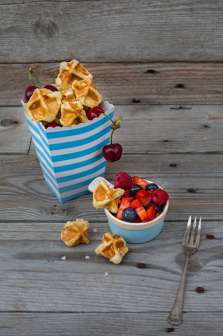 Waffle bites in a paper bag with cherries and berries