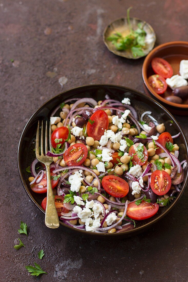 Chickpea salad with cherry tomatoes, feta cheese, onions, parsley and Kalamata olives