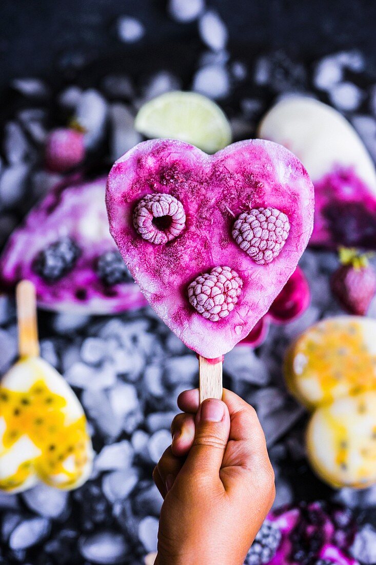 A child holding a raspberry yoghurt ice lolly