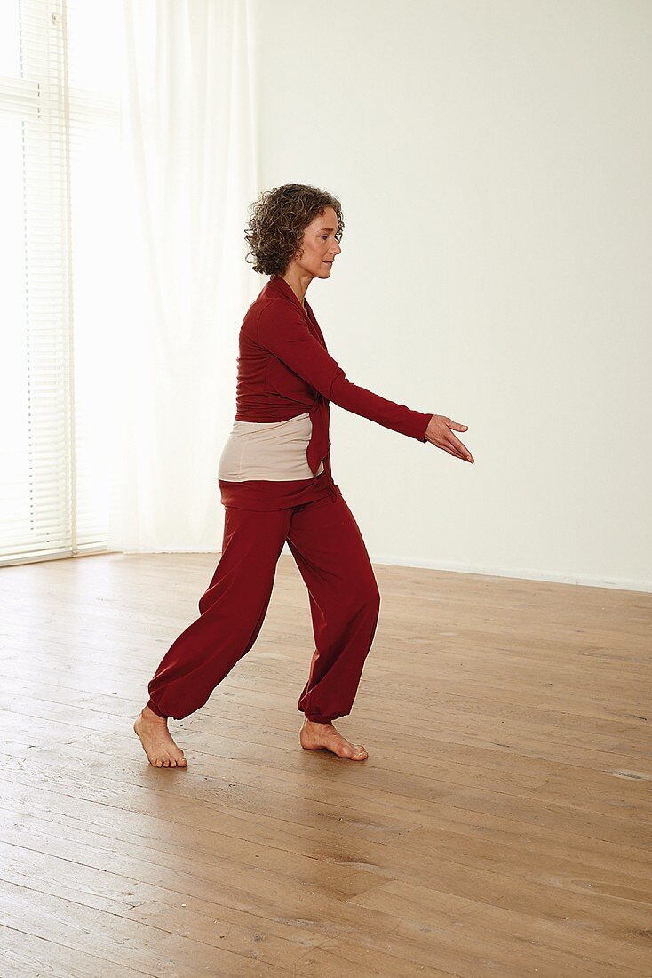 Carrying the ball in front of shoulders (qigong) – Step 3: turn to the left