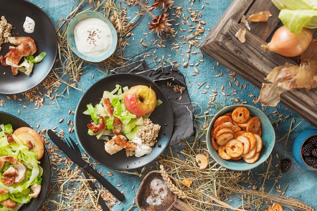 Salad with turkey strips and baked apples on an autumnal laid table