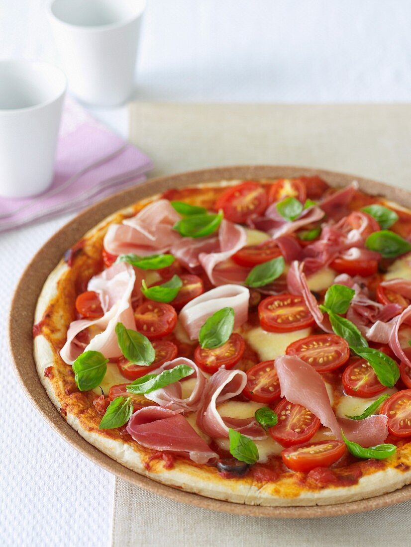Tomaten-Schinken-Pizza mit Basilikum