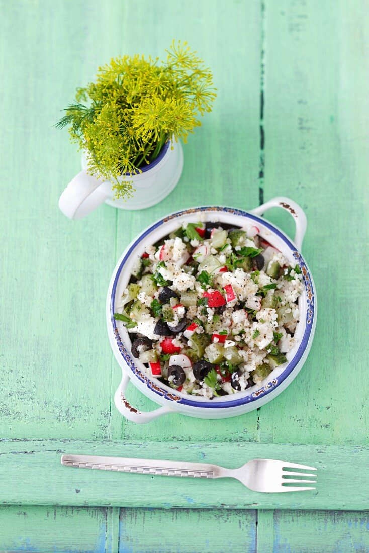 Barley salad with feta cheese, sour gherkins, radishes and black olives