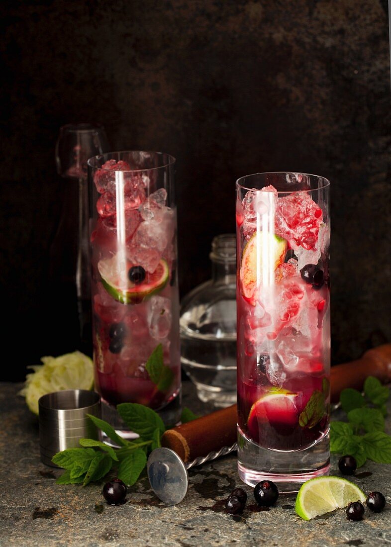Long drinks with rum, blackcurrant syrup, lime, mint and ice cubes