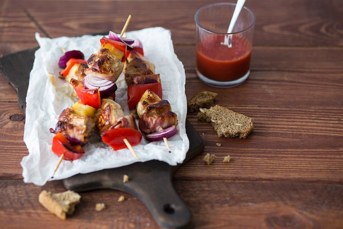 Chicken kebabs with pineapple, bacon, red peppers and onions