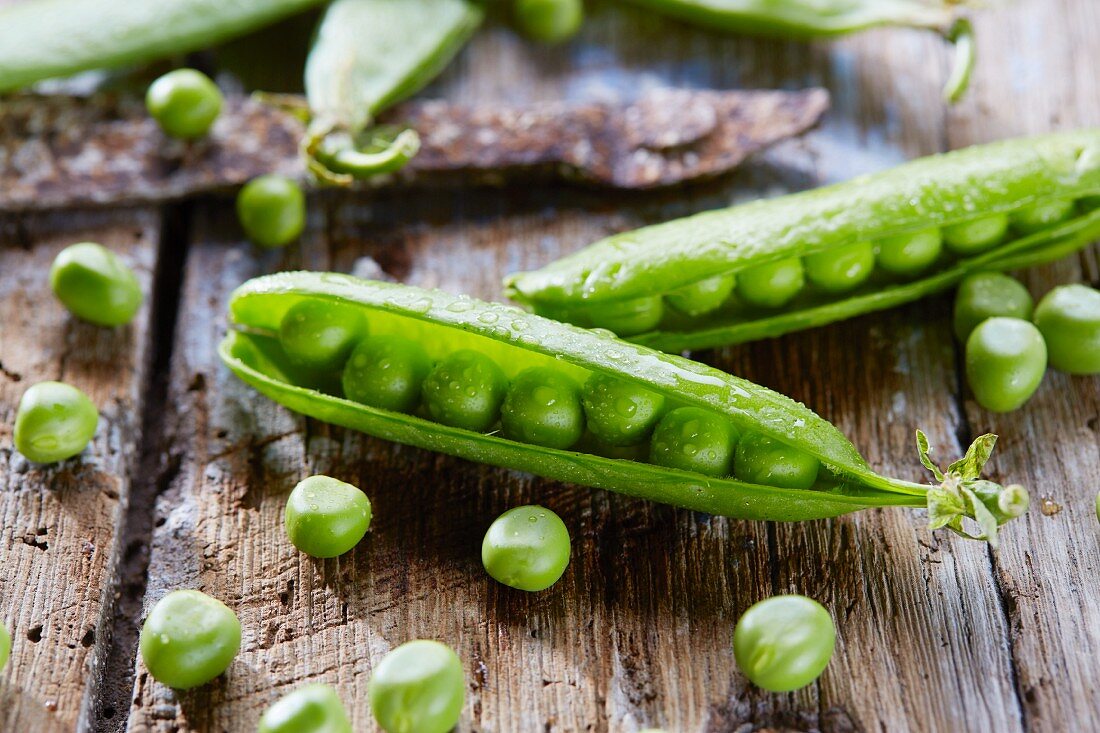 Pea pods on a wooden surface