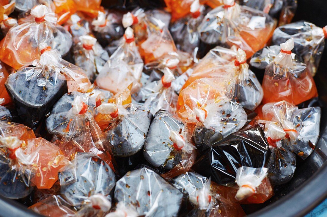 Chili- und Sojasauce in Plastiksäckchen auf dem Markt