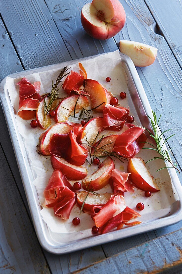 Oven-roasted peaches with ham, redcurrants and rosemary