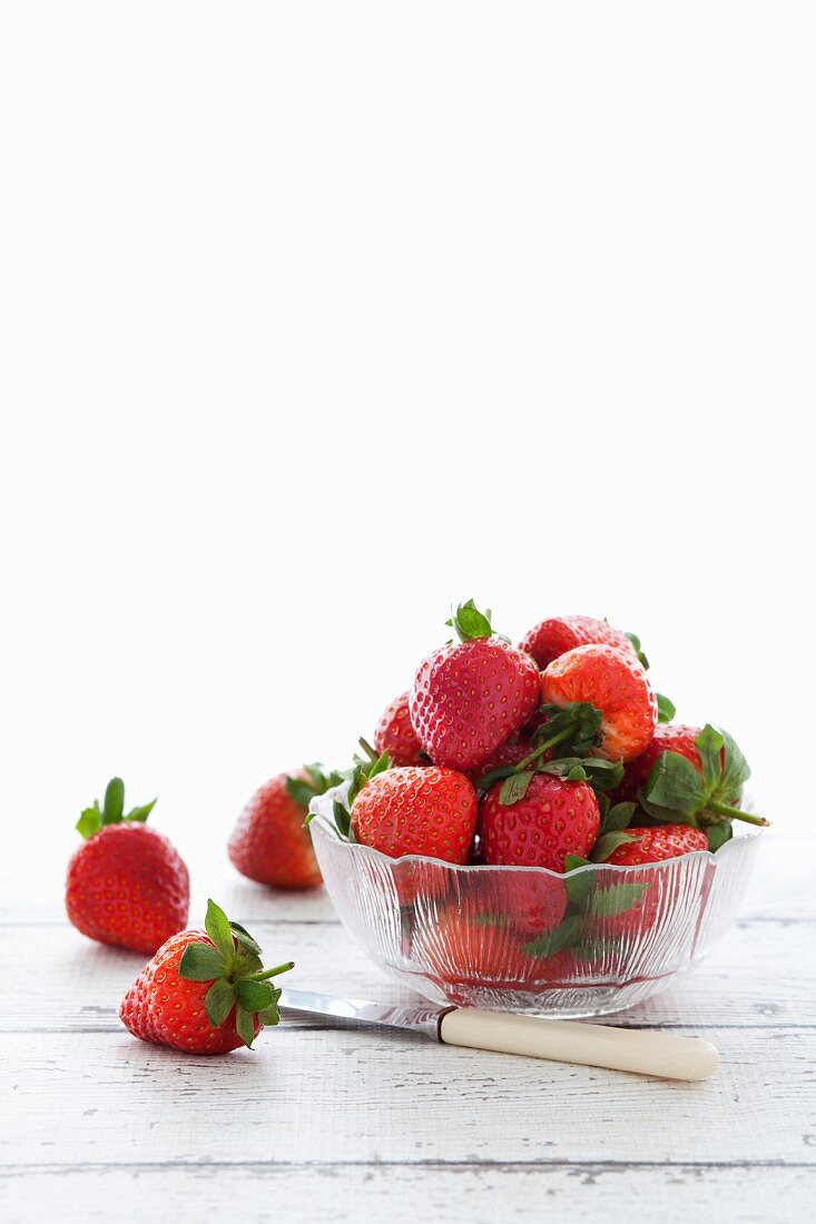 Frische Erdbeeren im Glasschälchen und daneben