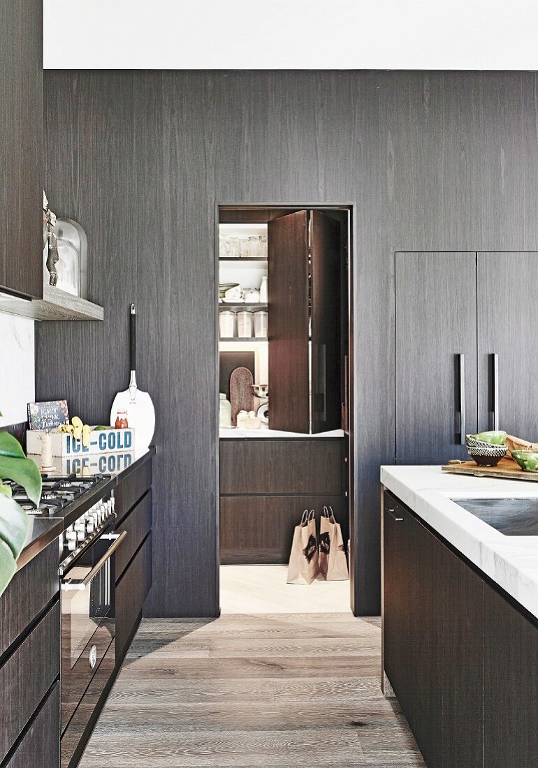 Black kitchen with dark wood, view of the pantry