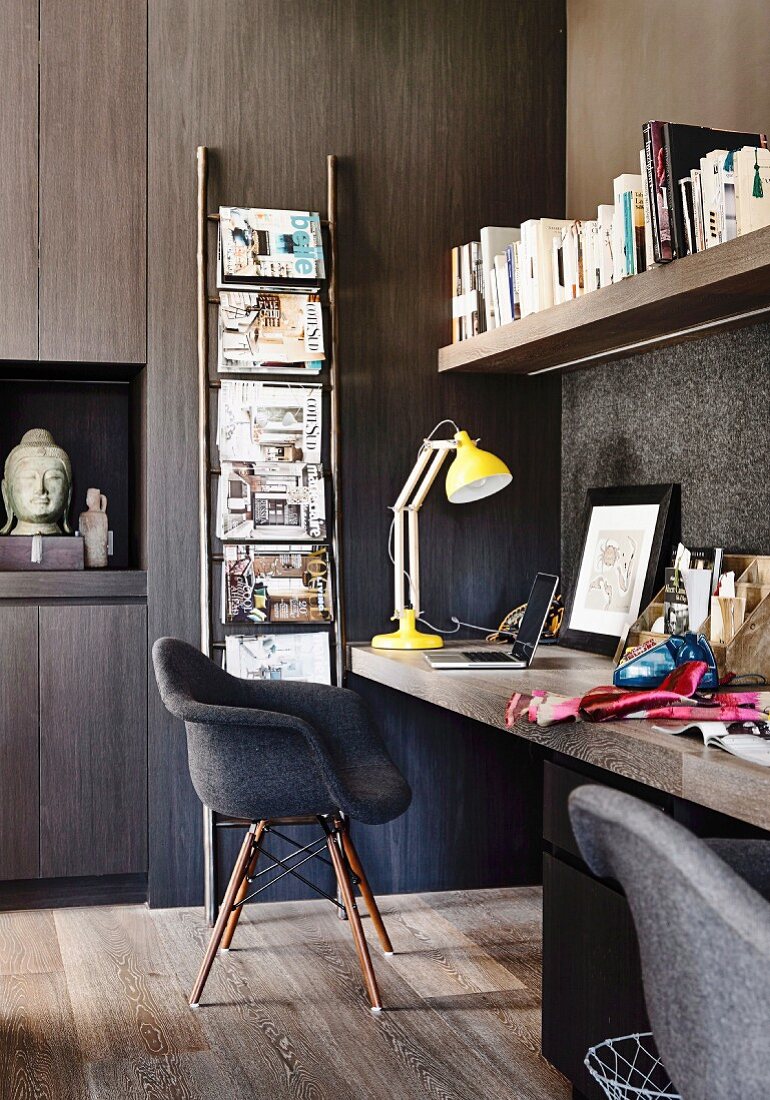 Dark office with clad wall and yellow desk lamp