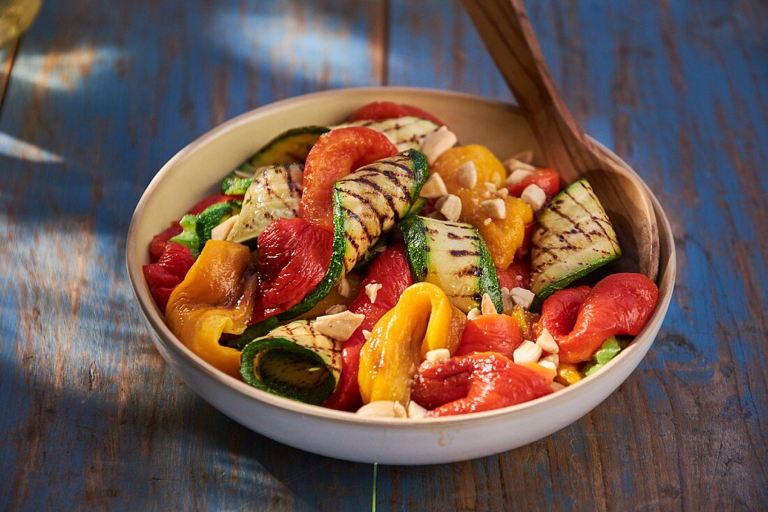 A bowl of grilled vegetables on a table outside