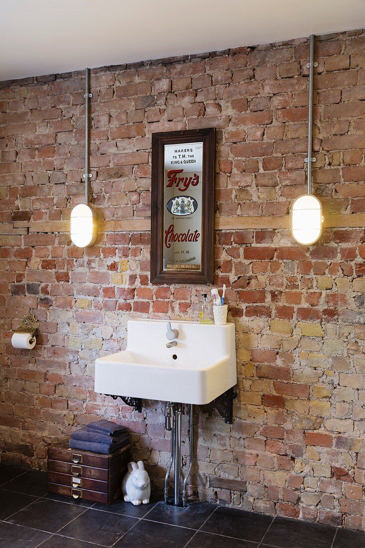 Sink mounted on unrendered brick wall