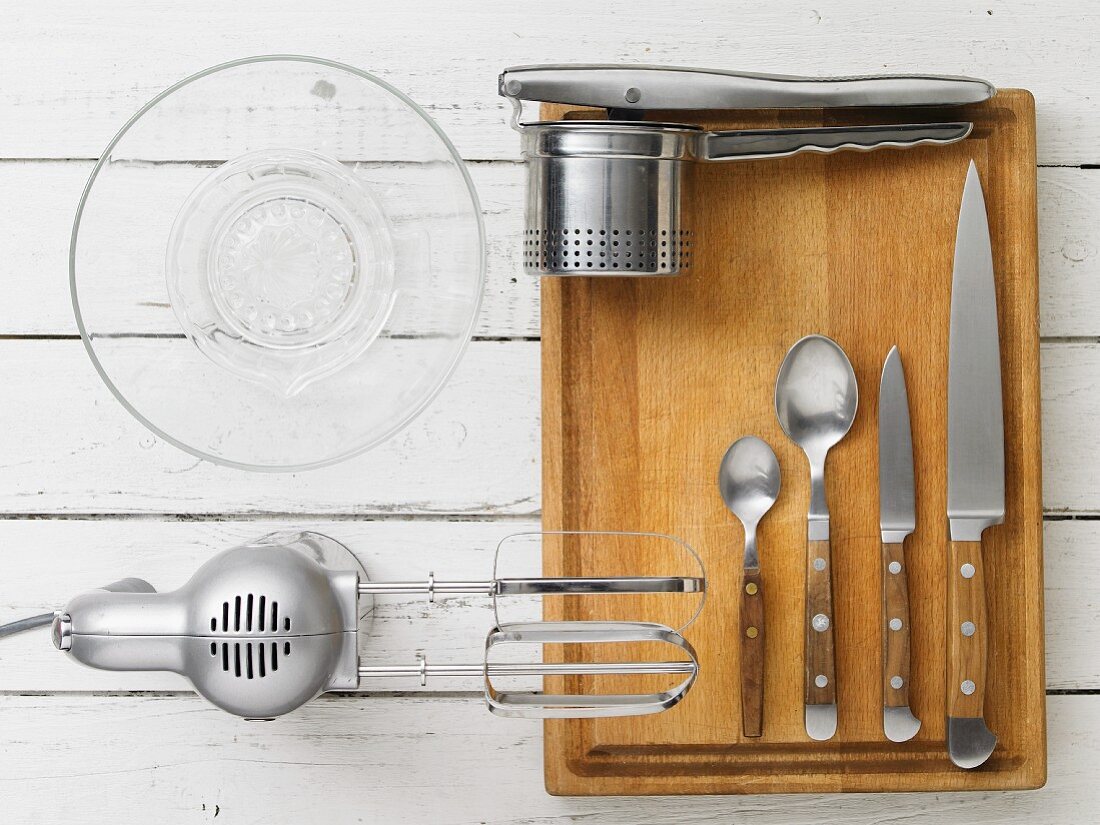 Various kitchen utensils: a mixer, a potato press, a citrus juicer and cutlery