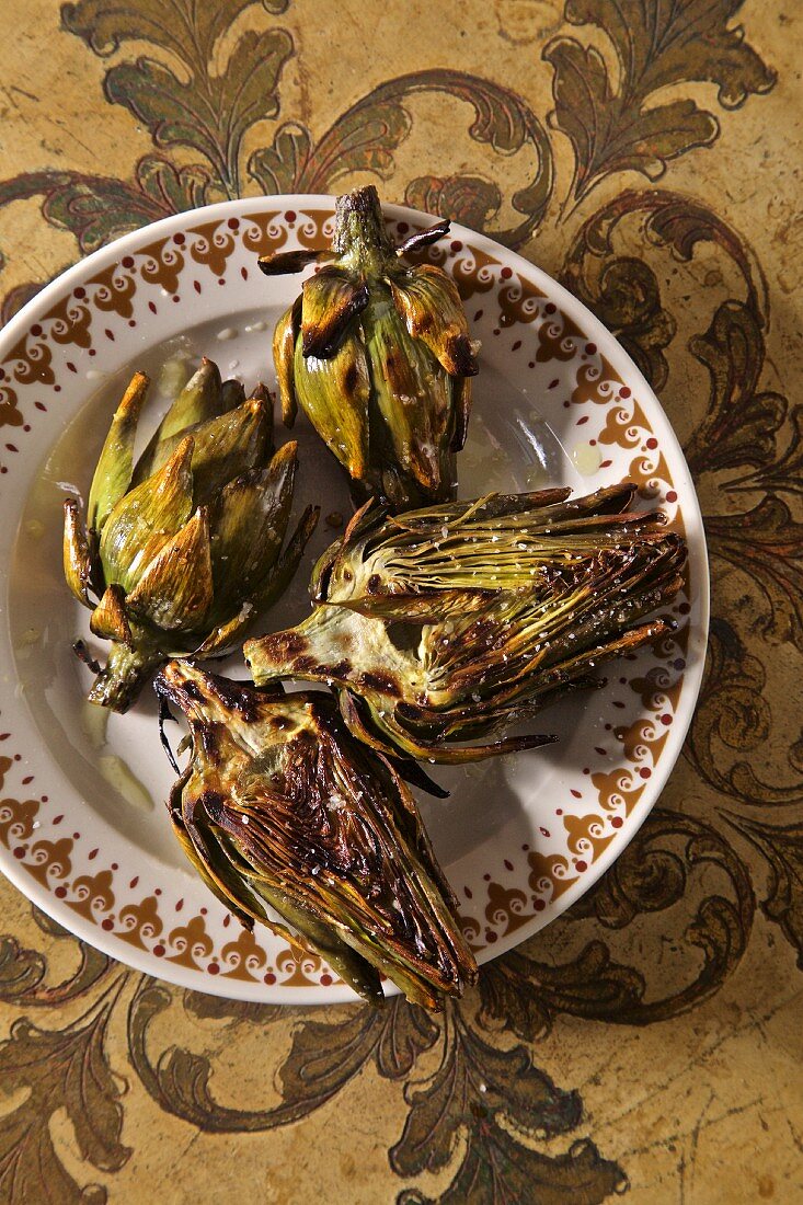 Grilled artichokes on a plate with salt