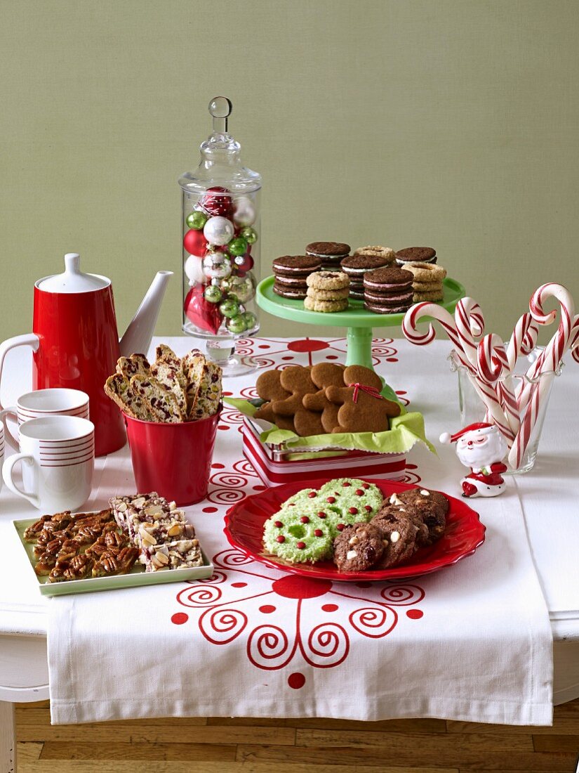 A selection of various Christmas biscuits with candy canes and coffee