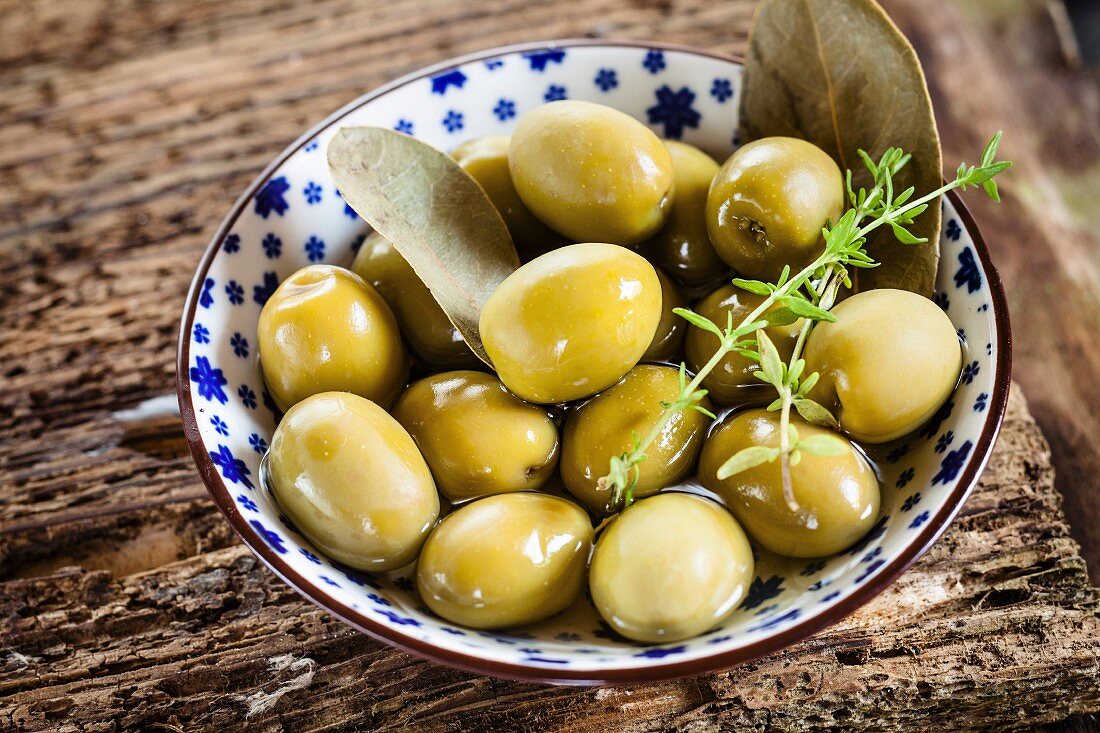 Eingelegte grüne Oliven mit Thymianzweig