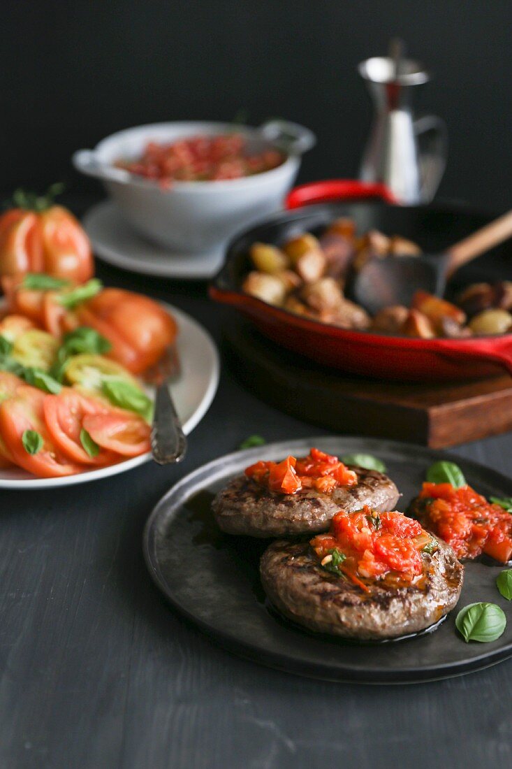 Burgers with tomato salsa, beef tomatoes and fried potatoes