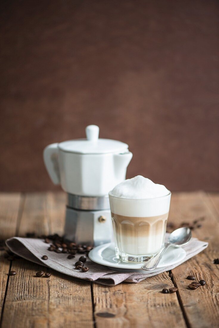An espresso jug, a cappuccino and coffee beans