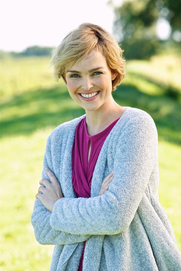 A young woman wearing a top and a fluffy cardigan