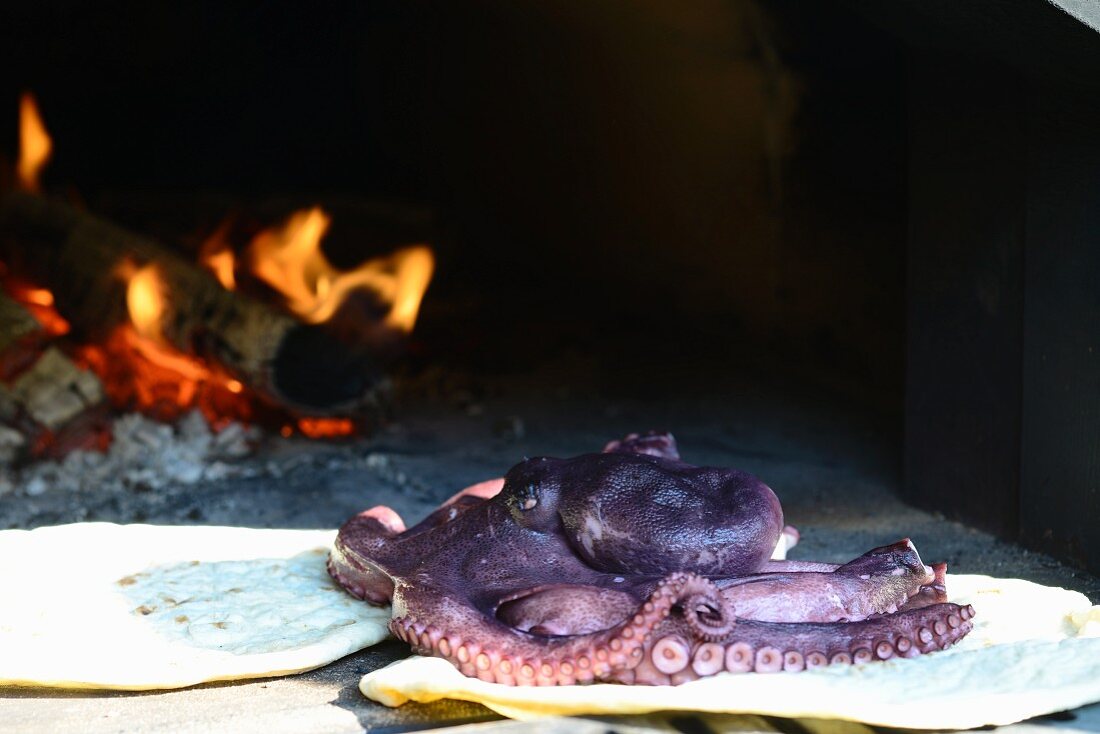 Unleavened bread and a whole octopus in a wood-fired oven