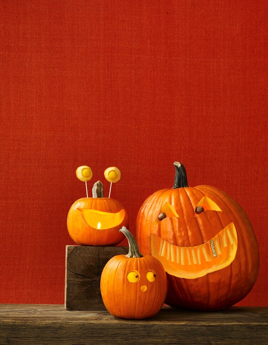 Drei Halloween-Kürbissse mit gruseligen Gesichtern
