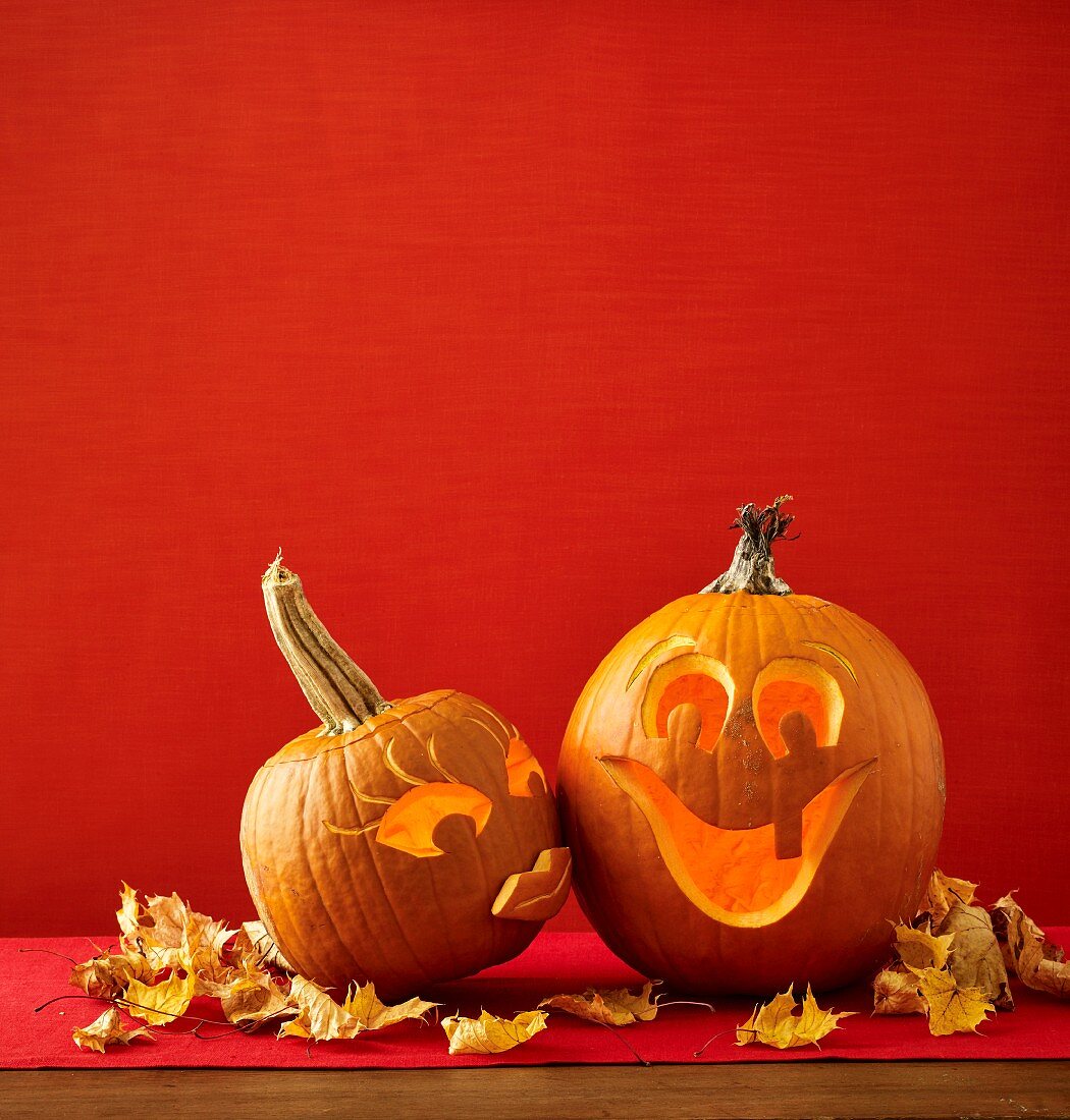 Two kissing Halloween pumpkins carved with faces