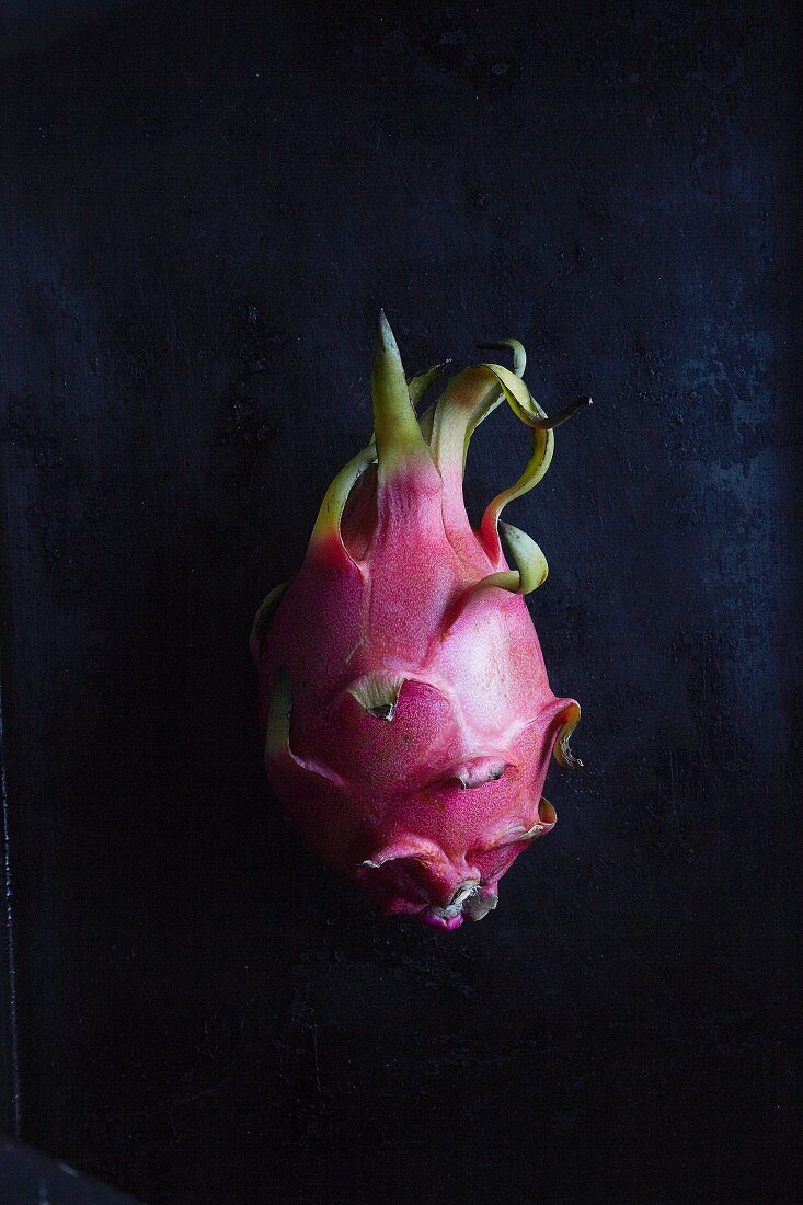 Eine Pitahaya (Drachenfrucht) vor schwarzem Hintergrund